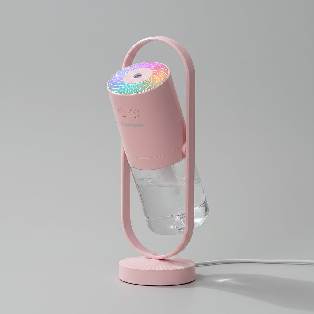 Pink handheld fan with colorful light on a wooden surface near a window